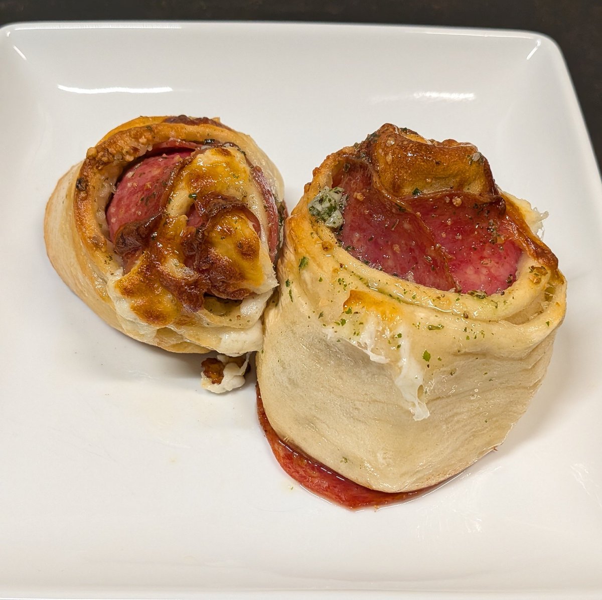 WeeknightDinner's tweet photo. I usually don't make dinner on Sunday nights, but sometimes I experiment.  These are salami and cheese rolled up in pizza dough.  I drizzled them in herby garlic butter. https://t.co/9IBHlbfq1k