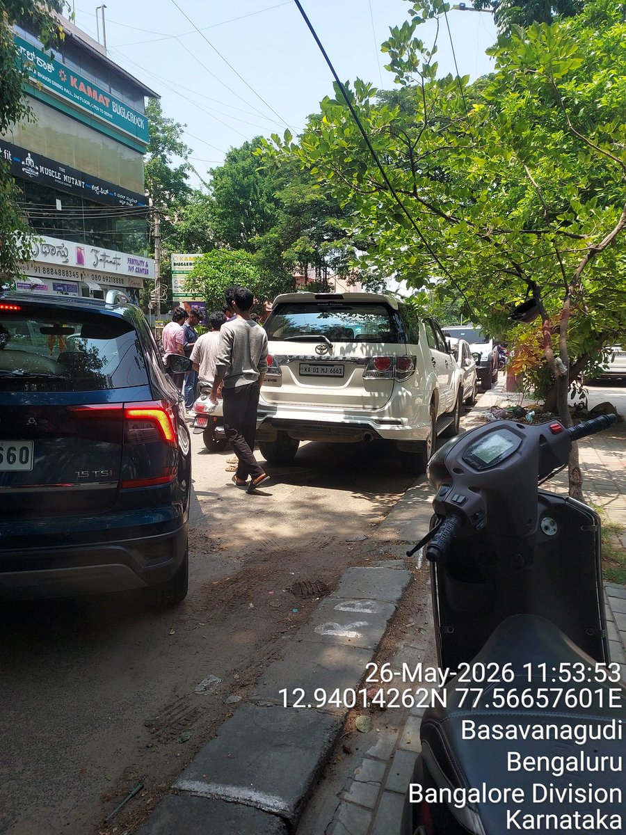 SaveBasavangudi's tweet photo. Bull Temple Road, Basavanagudi | 26-05-2026 11:53 AM

College of engineering students parked bikes/cars blocking house gates daily. 
Resident owner cannot take out his own car. See photo. trying 112 to clear, everyday need this?

This is "unauthorised parking mafia!!???" around colleges. Gated houses held hostage.

@GBA_Comm @BlrCityPolice @DCPTrSouthBCP 
@acpsouthtrf
@basvanguditrfps

Qa1. Tow vehicles blocking gates - Sec 122 MV Act
2. Book vehicle owners + fine Rs 1000/vehicle  
3. Permanent "PARKING at NO Parking area - 
Gate blocked "

Who has to provide parking for engineer's students

Residents are not free parking lots. ATR in 48hrs pls.

#BullTempleRoad #ParkingMafia?

 @Jointcptraffic