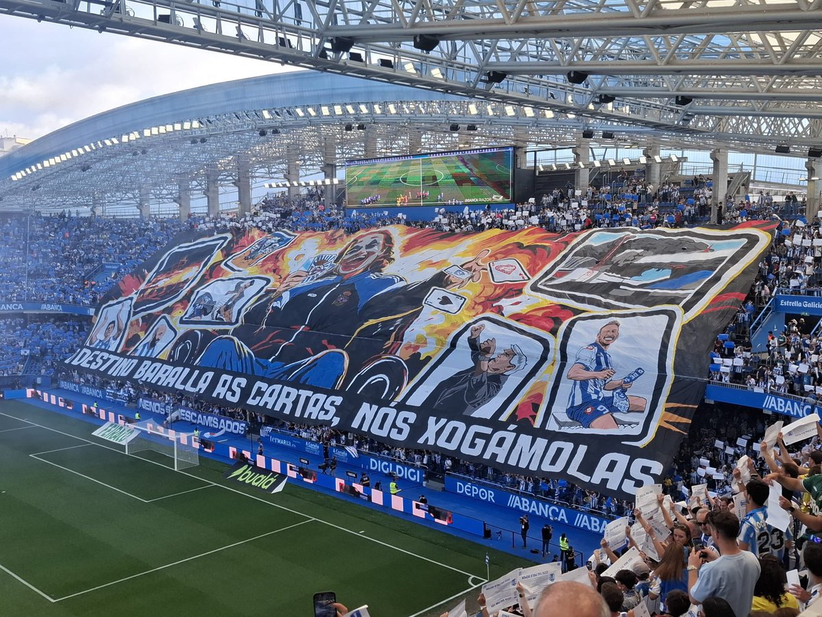 UltrasPresent's tweet photo. Gran tifo de los Riazor Blues 🔵⚪️ plasmando al JOKER con una chaqueta del RCDepor y las cartas con el escudo y abajo la frase:

“EL DESTINO BARAJA LAS CARTAS, NOSOTROS LAS JUGAMOS” 

RCDeportivo - UD Las Palmas. https://t.co/qtw6yy1GMh