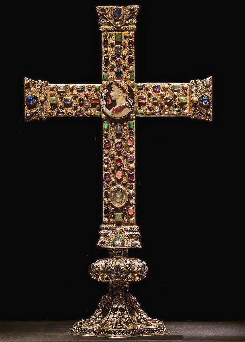 histories_arch's tweet photo. A masterpiece of medieval goldsmithing is the Lothair Cross (Lotharkreuz). It is an extraordinary crux gemmata (processional cross covered with precious stones) created around 1000 AD, likely in Cologne, Germany 🇩🇪

Today, the work is housed in the famous Treasury of Aachen Cathedral (AachenerDomschatz), one of the most important sacred art complexes in Europe. It has an oak core entirely covered in gold and silver-gilt leaf. It is decorated with 102 gems and 35 pearls, arranged in exquisite filigree. The decorated Gothic base on which it rests is a later addition, dating back to the 14th century.

The cross is a key monument of Ottonian imperial ideology (it was likely commissioned or donated by Emperor Otto III). It combines Christian religious symbols with the prestige of the Roman and Carolingian past according to the practice of reuse (spolia);

The Cameo of Augustus: At the exact center of the cross stands a Roman cameo from 1st century AD depicting the profile of the Roman Emperor Augustus wearing a laurel wreath. This central placement served to legitimize the power of the emperors of the Holy Roman Empire, positioning them as direct successors of Rome.

The Seal of Lothair: Set into the lower part of the vertical arm is a rock crystal seal that belonged to the Carolingian king LothairII (9th century). The seal bears his portrait and the inscription "
+XPE ADIVVA HLOTARIVM REG"
("O Christ, help King Lothair").

The Back: Contrasting with the opulence of the front, the back of the cross is a flat silver plate engraved with a delicate and dramatic Crucifixion of Jesus. The hand of God the Father falls upon it, holding a laurel wreath for the Son.

#archaeohistories