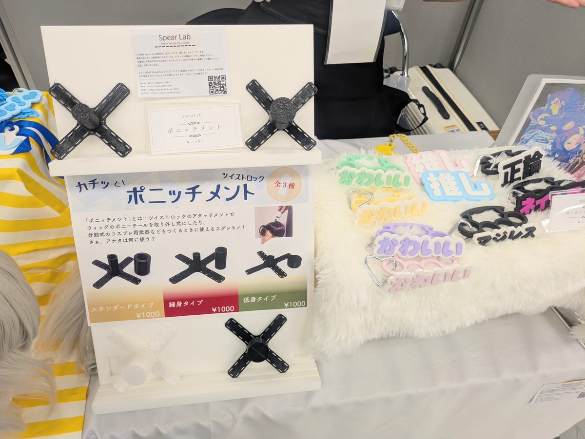 12KEI_robot's tweet photo. なべじるさんのポニッチメント！
コスプレ等で使用するウィッグの飛び出るところを取り外し可能にする道具！これは便利すぎる…
数多のコスプレイヤーを救っている…！

エメツ/十束玩具さんのゴム銃を実際に触って体験できたのが嬉しすぎる。デザインも機構もカッコよすぎ…

#JRRF #JRRF2026 https://t.co/FThoqJh1SE