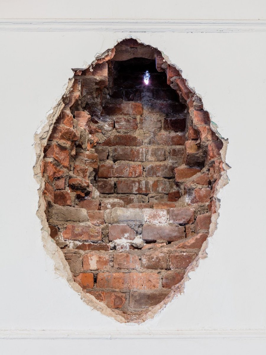 MoMAPS1's tweet photo. We are saddened to learn of Alan Saret’s passing at 81. 

As part of our very first exhibition, "Rooms" in 1976, Saret carved an aperture into our brick wall and created “The Hole at P.S.1, Fifth Solar Chthonic Wall Temple.” This artist intervention has let light into MoMA PS1 ever since. Saret, who maintained his studio just down the road in Long Island City, showed a generation of artists that sculpture could be an opening in the wall, a tangle of wire, or a formless organic illusion.

We are lucky to be reminded of him every day when the sunlight strikes the exterior of our building and the light puddles in our hallway.

_
Alan Saret, “The Hole at P.S.1, Fifth Solar Chthonic Wall Temple,” 1976. Brick wall and sun, 30" x 22" x 18" x 93,000,000 miles.