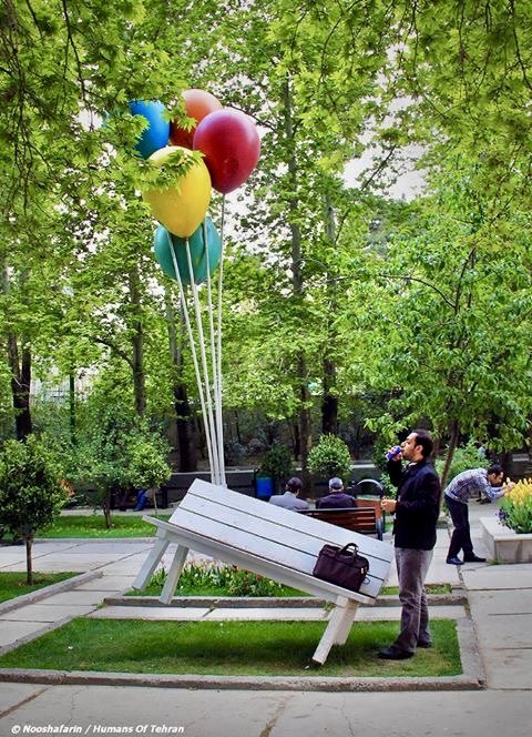 CoolThinggs's tweet photo. This is a public art installation.

The watermark in the corner reads “Nooshafarin / Humans of Tehran”, which tells us:

 • What: A sculpture of a white park bench being “lifted” by giant colorful balloons, tilted at an angle as if about to float away https://t.co/TrGG600n6y