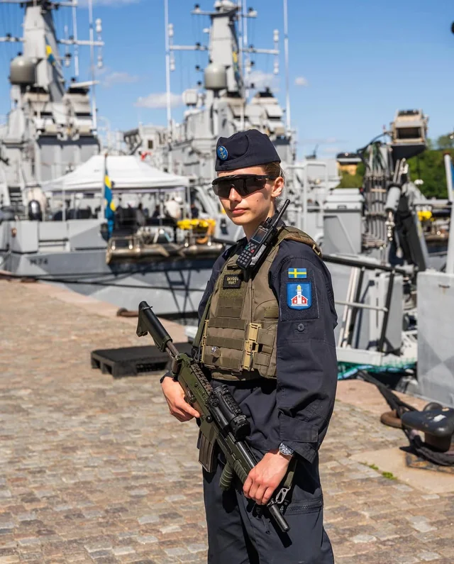 Koster Class Swedish sailor stands near the Koster-class mine countermeasure vessels ...