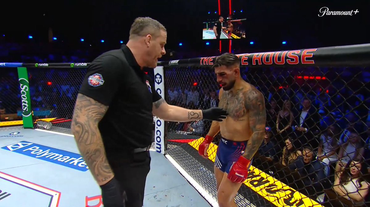 VGUBrian's tweet photo. @Topuriailia is not wanting to go down without a fight but the ringside doctor has said he can NOT continue. The crowd is going wild and the @ufc is going to allow it to continue!

@Justin_Gaethje has absolutely beaten him like we have never seen before. 

#UFCFreedom250 #UFC https://t.co/SL7XDhoQIl
