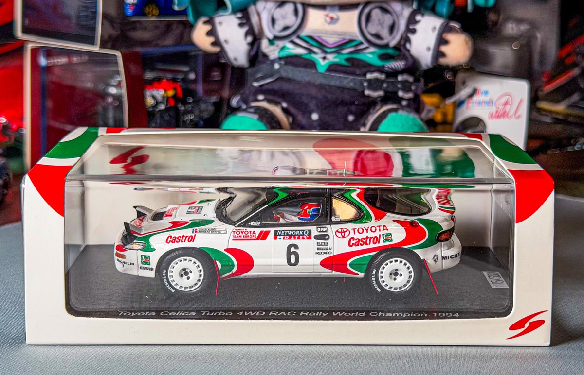 Legacy_BL_jun's tweet photo. #Spark #WRC
Spark 1/43 Toyota Celica Turbo 4WD RAC Rally World Champion Didier Auriol / Bemard Occelli Limited 300 pcs.
こちらも東京・新橋にあるSpark Gallery TOKYO限定モデルになります。
そもそもセリカ ST185 グループA仕様のモデルというのが少ないのでWRCファン注目です。

ケースも往年のカストロールカラーになっていてとてもオシャレですね。

【以下解説】
今回のモデルとなったセリカは、1994年のWRCでフランス人初のドライバーズタイトルを獲得したディディエ・オリオール / ベルナール・オチェッリ組のマシンで、最終戦RAC（英国）の仕様になっています。

1994年はトヨタがカンクネン&オリオールというゴールデンコンビで迎えた2年目、セリカ ST185型は3年目という熟成ピークの年でした。

オリオールは、第4戦地元ツール・ド・コルスにて神懸かりなドライビングで強敵スバル・インプレッサのエースであるカルロス・サインツを振り切ってシーズン初勝利。

第6戦のアルゼンチンでもサインツと僅差のバトルを制し2勝目、最終戦直前のイタリア サンレモ・ラリーでも最終日ゴール直前ににサインツを大逆転し3勝目。

その他のラリーでも安定した上位入賞を重ねた結果最終戦で6位以上入賞、サインツ2位以下でチャンピオン獲得という非常に有利な状況に。

しかしながら最終戦RACはシーズン屈指の難コース。そしてオリオール自身もこのRACを得意としていなかったのです。
前戦サンレモから新型セリカST205にチェンジしたカンクネンが上位入賞でサインツ・スバルにプレッシャーをかけてオリオールのチャンピオンを支援する作戦でした。

が、初日の公園ステージ内にあるウォータースプラッシュの手前の切り株にセリカの足回りをぶつけてしまったことでスピードを出すことがままならない状況で90位近くまで転落。

なんとか修復し、挽回を図った2日目早々にコースアウトからの転倒、その後ターボブローなど不運が続きました。それでもオリオールとTTEは決して諦めることなくセリカを都度修復し、ステージを果敢に攻めていきました。

3日目で9位まで這い上がってきました。こうなると慌ただしくなったのがスバル側。仮に6位に浮上するとトップを走る地元初優勝を狙うコリン・マクレーにチームオーダーで2位に下がってもらう必要が出てきます。

しかしながら、イギリスのチームで、スバルをトップチームに引き上げたマクレーの心情を考えるととても難しいものです。（それ引きずって翌年についにマクレーキック事件が発生）

そんな中での4日目・最終日。難しい選択を求められるチームの不安がサインツも伝わったのか雨の中の高速コーナーのアプローチ、ほんのわずかラインを外したインプレッサはコース外の土手に滑り落ちてしまいました。

サインツとコ・ドライバーのルイス・モヤは周囲を観客を呼んで必死にコースに戻ろうしましたが、連日の雨で柔らかくなった地面はインプレッサをなかなかコースに戻してくれません。
その間にも3位のカンクネンなど後続のマシンが次々とその横を通り過ぎていきます。

そしてついに満身創痍のオリオールのセリカにも先を越されてしまいました。

それからしばらくしてようやくインプレッサをコースに戻せましたが、既に入賞のチャンスもなく、戻す際に駆動系にダメージを与えてしまいリタイアを選択するしかなかったのです。

その瞬間オリオールのチャンピオンが決定しましたが、ゴールまでの残りのステージを慎重にセリカを大事に大事に走らせ見事6位入賞で文句無しのフランス人初のWRCチャンピオンが誕生しました。