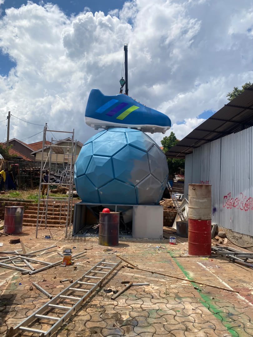 PyeparFaisal's tweet photo. It takes you 5-7 seconds to look at this structure, which took @vacker_advert 27 men to build, over 4 weeks... 

This is the COLD REALITY when it comes to #OOH/ #billboard placements. 

Last week, I wrote about how @DStvUganda & Vacker got Ugandans excited for the World Cup. Today, I want to talk about the people behind the build.

📌 Before motorists/ passersby stop to take pictures at Jinja Road roundabout, there was design ideation, then came steel fabrication, moulding, 3D work, sanding, painting, panel installation, and finally, crane deployment.

The finished installation may carry the DStv brand, but its fingerprints belong to 27 people. We often measure advertising in impressions, views, and reach, but rarely do we measure it in craftsmanship. 

We (myself included) usually celebrate creatives and brands all the time, but today, I celebrate the builders. Tag an #OOH project/ #billboard/ team whose craftsmanship deserves recognition.