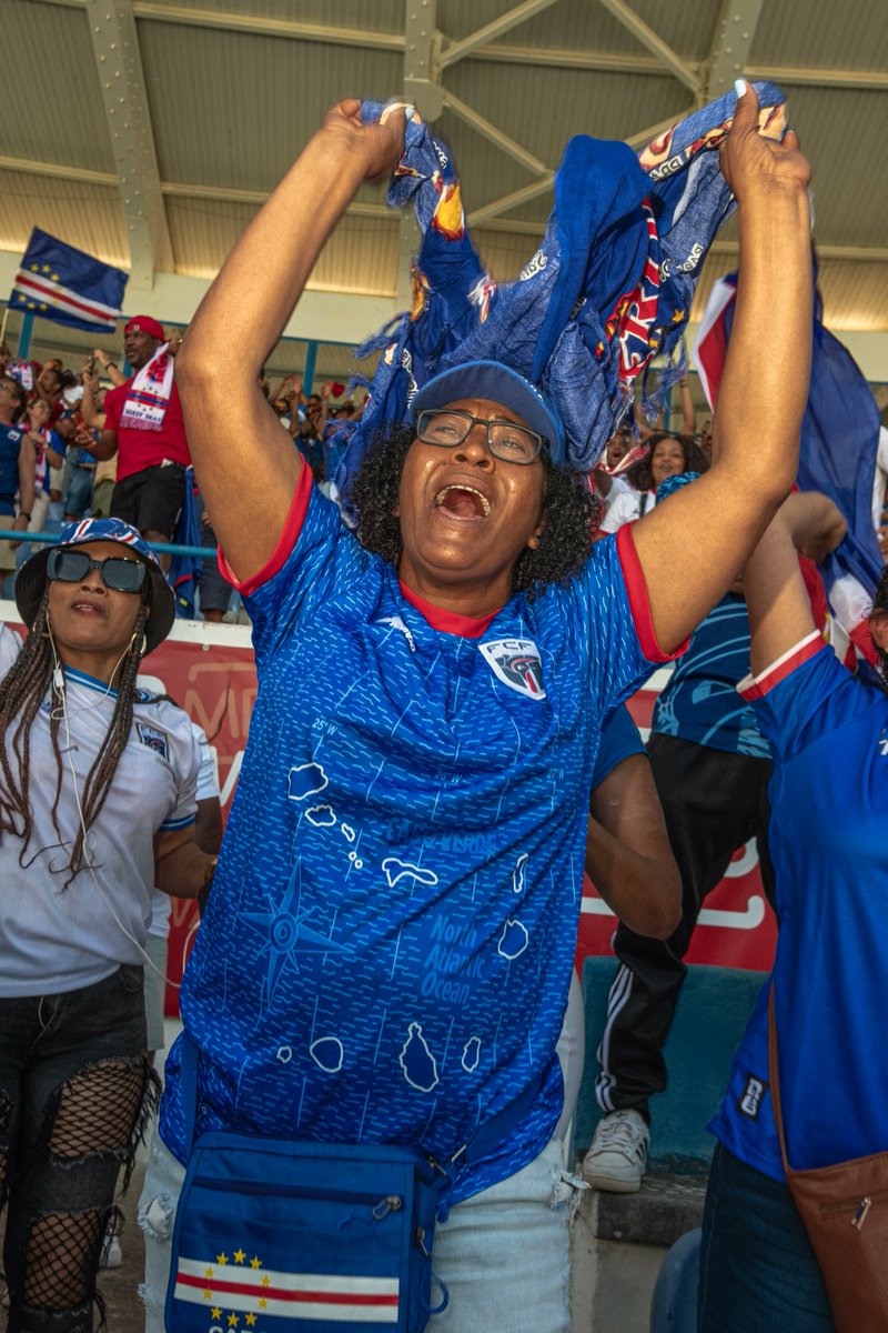 copaalemdacopa's tweet photo. Cabo Verde vai fazer sua primeira partida na história Copas e o pequeno arquipélago vai parar. Mas o impacto também será visto em Portugal, onde vivem cerca de 50 mil caboverdianos: cerca de 10% da população da nação africana.

De acordo com dados oficiais da AIMA, a Agência para a Integração de Migrações e Asilo, caboverdianos formam a quinta maior comunidade estrangeira de Portugal, atrás de brasileiros, indianos, angolanos e ucranianos, todos oriundos de nações muito mais populosas.

É uma relação óbvia pelo passado colonial: Cabo Verde era inabitado quando os portugueses chegaram por lá em 1456, ainda procurando o caminho para a Índia. Primeiro, foi um posto de descanso e abastecimento para navegadores, depois, prosperou como centro do tráfico de escravizados para as Américas.

Aliás, vale a menção: devido ao período da União Ibérica, o duelo entre Cabo Verde e Espanha pode ser enquadrado como um dos vários entre ex-colônia e ex-metópole da Copa do Mundo.

Quando o tráfico de escravizados foi proibido no Atlântico, Cabo Verde perdeu sua principal função. Viveu séculos de abandono por Portugal, que também já estava longe de ser a potência de antes. Ainda assim, durante a ditadura salazarista, Portugal se recusava a abrir mão de suas colônias na África, indo na contramão da onda de independências na África após a Segunda Guerra Mundial.

Naturalmente, muitos caboverdianos decidiram migrar para a metrópole e lá procurar uma vida melhor. Esse movimento aconteceu durante boa parte  do século XX e continuou após a independência, que veio em 1975.

Cabo Verde tem hoje uma economia baseada em serviços e turismo, e com área e população diminutas e política estável, possui um dos melhores IDHs da África. Mas o movimento migratório para Portugal, pela proximidade linguística e cultural deixados pela colonização, ainda é grande.

Quando Cabo Verde garantiu a sua classificação para a Copa do Mundo pela primeira vez, no final de 2025, Lisboa explodiu em comemoração. Hoje, certamente o mesmo vai acontecer, ainda mais em um duelo contra os espanhóis, vizinhos e rivais dos portugueses, juntando caboverdianos com nativos na torcida.

Independente do resultado, Cabo Verde terá um momento de glória e a se comemorar ao entrar em campo em uma Copa e enfrentar uma campeã do mundo.