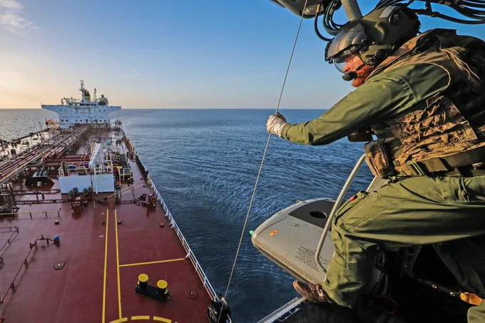 Aircrew help winch Royal Marines onto the deck
