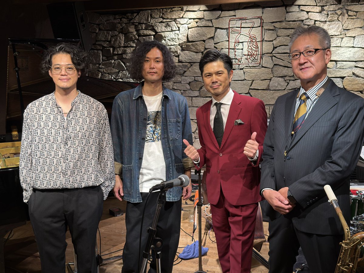 kurata1's tweet photo. 《倉田大輔クァルテット》
#倉田大輔 (ds) #宮川純 (pf) #清水昭好 (b) #岩持芳宏 (bsax)
 
▶ニューヨーク、日本で、長年の華麗な出演歴、共演歴を誇り、現在は名古屋を拠点にご活躍をされているドラマー／パーカッショニスト 倉田大輔さんのリーダーライブがBODY&SOULで開催されました。
 
▶スタンダード曲を中心に、倉田さんのオリジナル曲も演奏されました。
 
▶2nd.セットからの参加になりました。バンドメンバーがステージに登場し、倉田さんがマイクを取り、改めてご挨拶と一曲目の曲紹介をされました。倉田さんがニューヨーク時代に住んでいたブルックリンのエリアの名前がSunsetparkで、そこには公園があって、マンハッタンの方に綺麗な夕日が見えたそうです。「倉田大輔というドラマーをフィーチャー致しまして、♪A Sunset In The Sunsetparkを演奏します。張り切ってどうぞ！」と声を張り、観客は大爆笑します。
 
▶倉田さんの掛け声で一斉に演奏がスタートします。岩持さんのバリトンサックスソロになり、低く、厚みのある特徴的な音色を響かせ、大きく演奏していきます。上品な音色で滑らかに速度を上げ、軽快に演奏を進めていきます。岩持さんはソロパートが終わると、すっとステージ右に移動します。
 
▶その勢いを引き継いで、宮川さんのピアノソロでは、煌びやかな音でパワフルに弾き進みます。徐々に力感を増していき、大きく歌うように弾いていくと、倉田さんが呼応して、シャープなドラムサウンドで並走します。岩持さんがフロントに戻り、アンサンブルに続いて、倉田さんのドラムソロになります。
 
▶勢いよくマーチのようにドラムを叩き始め、強度を増していきます。宮川さんと楽しそうにやり取りしながら、軽やかにダイナミックなサウンドを響かせます。豪快な演奏ですが、音が澄んでいて、どっしりとした落ち着きが感じられます。倉田さんは静かな表情で、熱いドラムソロを繰り広げ、再び、岩持さんがバリトンサックスを吹き、鮮やかに演奏を結びます。
 
▶倉田さんが「岩持さんのクラリネットをフィーチャーして、♪Moonglowを小粋なスイングで演奏します」と話して、二曲目の演奏が始まります。クラリネットに、トリオが続き、倉田さんはブラシをリズミカルに回します。岩持さんのクラリネットソロになり、優雅な音色でゆったりと吹いていき、一転、パワフルな高い音で吹き進みます。爽やかなブラシ、穏やかなベースが並走し、岩持さんは高らかに吹いていきます。
 
▶その心地良いスイングの演奏を、お隣で聴いていらっしゃった京子ママが、「この曲ではダンスするのよ」と教えてくれます。宮川さんのピアノソロになり、粋なタッチで弾いていき、ころころと綺麗な音を転がすように弾き進みます。清水さんは、穏やかな温かい音でベースソロを弾き始めます。一音をくっきりと弾き、速度を増して速弾きを披露します。残響の短い、強い音で歌うように弾いていき、倉田さんのブラシが小気味良くリズムを刻みます。後半では、残響を操り、軽妙に歌うベースソロになりました。クラリネットが戻り、伸びやかな音で吹いていきました。
 
▶この日、倉田さんと岩持さんはスーツ姿で演奏されました。倉田さんの大学の先輩にテーラーをされているかたがいて、一度仕立ててみたらハマって、ステージでも着用するようになったそうです。岩持さんも倉田さんにご紹介されて、スーツを仕立てたそうです。バッチリときまっているお二人でした。
 
▶南青山時代のBODY&SOULには良く出演したが、ブルーノートで演奏したミュージシャンが頻繁に遊びに来て、僕もロイ・ハーグローヴと一緒に演奏した、と倉田さんが話します。さらに、「9月に閉店と聞いて、どうしても出演したくなり、ブッキングをお願いしました。ママ、ありがとうございます」と京子ママに感謝の気持ちを伝えます。
 
▶2nd.セット最後の♪I’ll Remember Aprilでは、倉田さんが聴かせるドラムソロを披露されました。緩急強弱を変え、観客の耳を惹きつけ、少しずつ全体的に強度を増していきます。シンバルを連打し、勢いを増し、ダイナミックなサウンドを放ちます。ストイックで静かな表情のまま、とても熱量の高いドラムソロで、2nd.セットを締めくくりました。
 
▶アンコールでは、京子ママに捧げて、♪Body And Soulが演奏されました。会場にいらっしゃっていたピアニストの平手裕紀さんがシットインされ、宮川さんと交互に演奏されました。バラードではなく、ダブルタイムで軽快な演奏となりました。
 
▶渋谷BODY&SOULでは最初で最後となった倉田さんのリーダーライブに参加できて幸いでした。選曲も演奏も素晴らしく、そして、心地良く、京子ママが楽しそうにお聴きになっているのが印象的でした。
 
▶アルバムには「倉田さんへ」と書いていただき、良い思い出ができました。