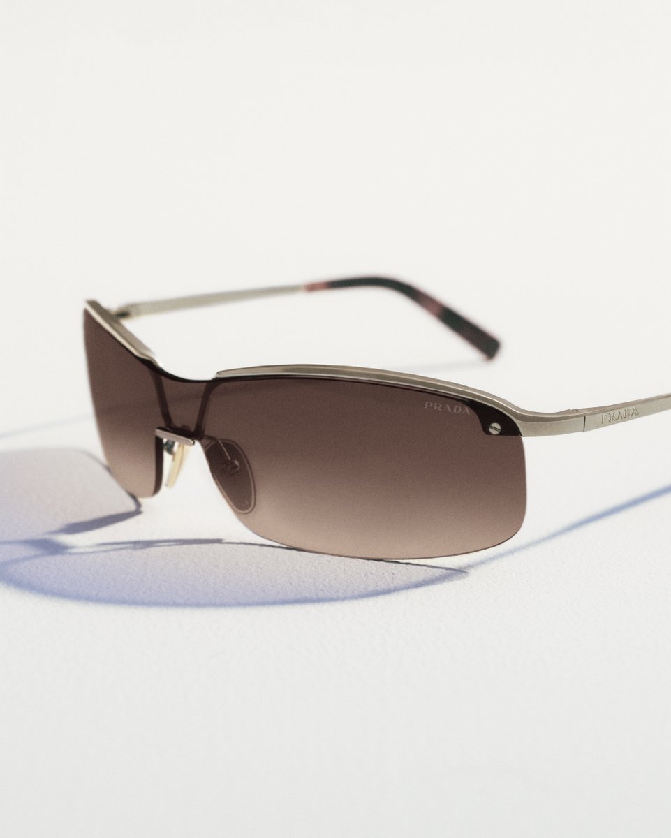 Prada's tweet photo. Prada Eyewear introduces minimalism in a lighter register, from the slim metal double bridge frame to a wraparound mask inspired by the early 00’s. 
Discover more: https://t.co/RofpvNvHR5 

 #PradaEyewear #Prada https://t.co/ImIBsE9Jzq