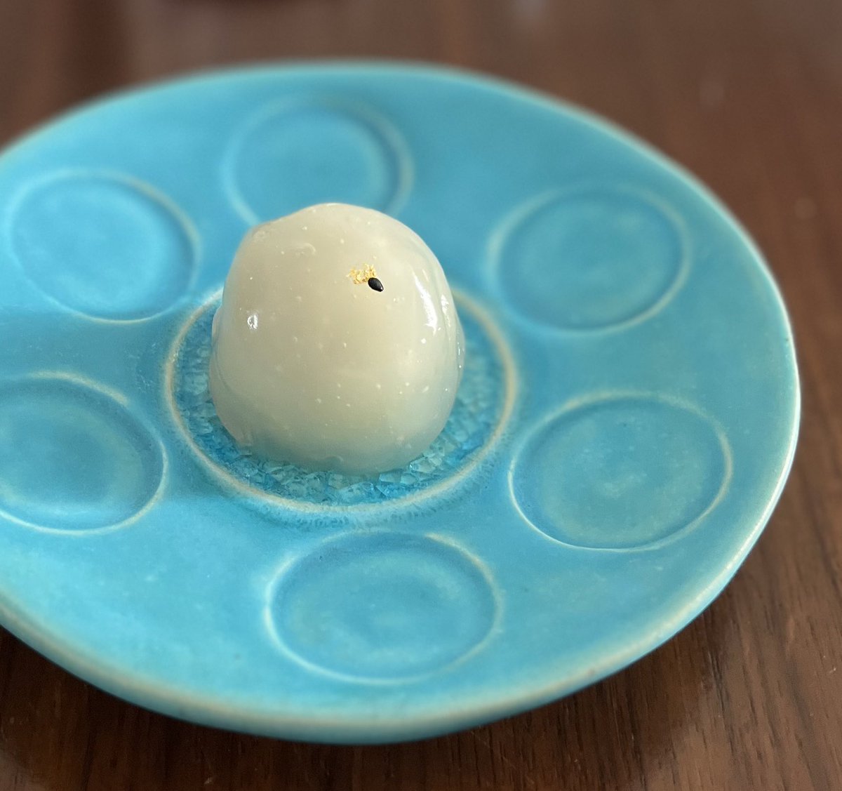 wagashibuyer's tweet photo. #販売情報

さあ、今日6/16は #和菓子の日。関東の高島屋5店舗では、和洋菓子バイヤーみんなで、1+6=7種類のお菓子を本店に受け取りに行き、日本橋の事務所に持ち込んで、各店ごとに仕分けてから、日本橋・新宿・横浜・玉川・柏の高島屋各店へ、それぞれ散ってハンドキャリーします。

既に5種類はご案内済み。あと二つありますが、まずは #青山紅谷 さんの葛まんじゅう『#蛍とぶ』です。薄く道明寺でこしあんを包みまして、葛生地でくるむスタイル。表面には金箔と胡麻をひとつあしらって、まさに蛍が飛んでいるさまを表現しています。

まさかね、葛生地の中に道明寺が入っているとは思わないですよね。こしあんが透けて見えますと、胡麻がよく分からないというのもあり、白い背景にする工夫でもあります。これもまた若旦那さんが修業した一幸庵さんから習ったもの。DNAが繋がっていくことも感じられる素晴らしさ👍

青山の本店に受け取りに行きまして、日本橋・新宿・横浜・玉川・柏 #高島屋 各店の #銘菓百選 にて、正午より販売致します予定です。配達のため、朝は玉川高島屋のイベントを不在にしています。

1個　税込500円

《高島屋限定：「和菓子の日」嘉祥菓子七種類》
①いいだばし萬年堂『ごま風流』
②神楽坂・五十鈴『ずんだ団子』
③麻布昇月堂『ピーカンナッツレーズン蒸し羊羹』
④一炉庵『葛焼き』（羊羹製）
⑤新橋・文銭堂本舗『嘉祥団子』
⑥三田・秋色庵大坂家『嘉祥饅頭』
⑦青山紅谷『葛まんじゅう』