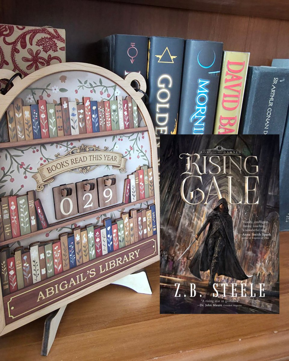 AuthorAMBurk's tweet photo. June has been a rough month so far. Between illnesses, migraines, and urgent care visits, our family has been dealing with pure insanity. 😂

But the good news about being sick? I can still read! 😍

Now, y’all — I’m super excited to tell you that this INCREDIBLE book releases TOMORROW, June 16th! I’m giving you a sneak peek here, but make sure to check out @ZB_Steele and preorder it for yourself!

I’m honored to have been both a beta reader and an ARC reader for "Rising Gale", the sequel to his indie hit "Whispers of the Storm" and the second book in the "Song of the Damned" series. I’ll be honest — I loved the first book so much that I wondered if Book 2 could keep the same pace, emotional depth, characters, and world-building.

Y’ALL.

I finished this last night and my jaw is still on the floor. "Rising Gale" was a seamless continuation that gave me everything I wanted from Book 2 and then some! It’s a much darker tale for our protagonist, and the storm clouds are definitely gathering for both Redlin and the Prisoner. I pride myself on guessing plot twists, but this book got me — and got me GOOD. Several major twists at the end have left me absolutely reeling and wishing Book 3 was already out!
Beyond the insane plot, the character development, world-building, and exposition are all top-notch. I tend to be picky with my praise, but I genuinely have no complaints with this one… which is wild considering it’s 633 pages on ebook. 😳

For the parents out there: this is solidly an adult book. There’s quite a lot of R-rated cursing, gory violence, and two open-door scenes (though not extremely detailed). There are also several dark themes including torture, execution, child sacrifice, and war. I highly recommend it for adults. If you’re a kiddo or teen, I’d suggest waiting a bit longer. 🙂

Okay, y’all — I’m giving you homework this time!

Go get this series, read it, and then DM me when you finish Book 2. I’m going CRAZY not being able to talk about THE THING THAT HAPPENS. 🙃

And let me know in the comments — who’s your favorite character? I’m personally a Juck fangirl myself! 💜

#BookReview #DarkFantasy #FantasyBooks #NewRelease #BookRecommendations #SongOfTheDamned