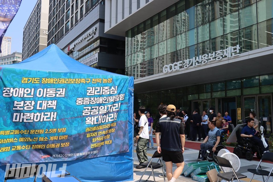 _BeMinor's tweet photo. [속보] 경기도 장애인들, 추미애 당선인 약속 요구하며 경기도청 앞 농성 시작

16일 오전 10시 20분경 경기장애인차별철폐연대 활동가들이 경기도청 경내에 위치한 경기신용보증재단 앞에 천막을 치고 농성에 돌입했습니다.

이들은 “선거 과정에서 발표된 장애인 정책과 공약은 장애인의 삶을 실질적으로 변화시킬 명확한 비전과 의지를 보여주지 못했다”며 추미애 도지사 당선인이 “구체적인 정책과 예산으로 응답해야 한다”고 요구하고 있습니다. 
https://t.co/bntMZ9N2tg