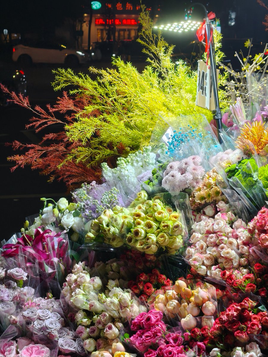 gurunathan03's tweet photo. Quick street snap – late afternoon light hitting a messy flower cart, passersby hurrying past like they’re in a rush, but this little burst of pink’s holding its own. https://t.co/lJytwnE2hi