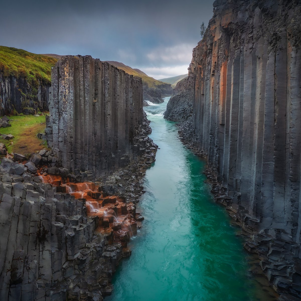 guidetoiceland's tweet photo. Studlagil canyon is one of East Iceland's most striking summer landscapes. ��💙

Hundreds of hexagonal basalt columns line the canyon walls, with bright turquoise glacial water flowing through the middle during the warm months. The canyon was hidden underwater until a hydroelectric project lowered the river, revealing its full beauty around 2009.