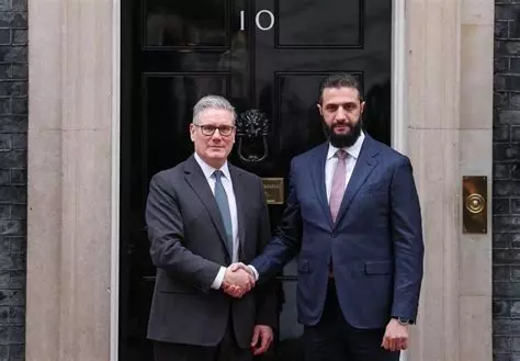 davidkurten's tweet photo. UK 2026:
- Little old ladies protesting a genocide by carrying 'Palestine Action' signs are arrested as terrorists.
- An actual head-chopping terrorist is welcomed to 10 Downing Street. https://t.co/ZprQelAZAg