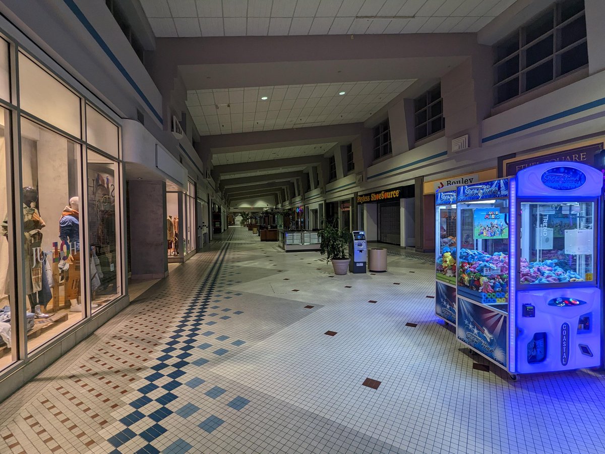 Tyras_Mikhail's tweet photo. Malls are not dying in Europe, but I have a distinct memory of walking through a dying mall.

It was my 13th or 14th birthday, and my parents took me to my favorite mall for pizza and to look at the video game/DVD store. However, what we did not know was that the mall was filing for bankruptcy and was days away from closing.

I remember immediately feeling like something was weird in the parking lot. Utterly empty. Our footsteps echoed off the concrete, even water dripping off pipes was audible due to the lack of engine noise.

There were barely any people. You had entire hallways of closed stores, utterly devoid of humanity. There wasn't even any music. Just rows and rows of shuttered stores, plain white brick and still dirty floor tiles.

Seeing my favorite place, utterly devoid of life, only the husk and fading memory of it remaining, really stuck with me. It felt like I was watching a terminally ill friend slowly dying in a hospital bed.

Generation Z has witnessed a lot of things they loved as children dying. Blockbuster and Toys R Us spring to mind. And liminal spaces, representations of locations that should be bustling with life, but are eerily empty, speak to us in a way they do not to other generations.