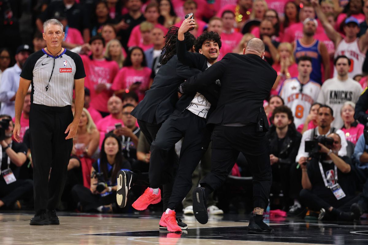 mySA's tweet photo. A fan rushed onto the court during the Spurs Finals game Wednesday night and filmed himself taking a selfie with Wemby. 🤭 That's got to be a lifetime ban, right? 🔗 https://t.co/NMAhVmtrS4 https://t.co/dvfTVvZ49t