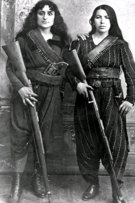 ankorinclan's tweet photo. Era 1895. El Imperio Otomano llevaba un año masacrando armenios. Y dos mujeres se plantaron frente a una cámara con rifles en la mano.

La de la derecha se llama Eghisapet Sultanian. La otra sigue sin nombre.

Lo que sabemos de Eghisapet lo contó décadas después su bisnieto, el músico Derek Sherinian, teclista de Dream Theater. En sus propias palabras: "Mi bisabuela, Yeghisapet, perdió a su marido en las masacres. Los turcos mataron a todos los hombres de las aldeas armenias y las mujeres, sus esposas, se vieron obligadas a tomar las armas y combatir. Tengo una fotografía de mi bisabuela con un arma en la mano. Pero mi abuela solo tenía dos o tres años en esa época."

Eso es todo lo que hay. Una frase. Una foto. Una niña de dos años que creció sin padre y cuya madre posó con un rifle para que alguien recordara que había existido.

El contexto pesa más que cualquier nombre.

Entre 1894 y 1896, el sultán Abdul Hamid II ordenó una campaña sistemática de exterminio contra la población armenia del Imperio Otomano. Las unidades de caballería kurda Hamidiye arrasaban aldeas. Los hombres eran ejecutados primero. Las mujeres y los niños quedaban solos. En diciembre de 1895, cerca de 3.000 armenios que se habían refugiado en la catedral de Urfa fueron quemados vivos dentro del edificio.

En ese contexto surgieron los Fedayi, término árabe que significa "los que se sacrifican." Civiles, hombres y mujeres, que formaron unidades de autodefensa cuando comprendieron que nadie más vendría. Combatieron en Sasun, en Zeitun, en Van. Cortaron líneas de telégrafo, atacaron suministros militares, protegieron aldeas de purgas. En la Rebelión de Zeitun de 1895-96, entre 1.500 y 6.000 armenios armados resistieron a 58.000 soldados otomanos con 12 cañones.

Los investigadores que analizaron esta fotografía encontraron algo desconcertante: los rifles parecen de utilería. El revólver tiene proporciones incorrectas. Probablemente son armas de estudio fotográfico, no las que usaban en el campo.

Eso no resuelve nada. Que posaran con armas falsas para una foto no significa que no fueran combatientes. Significa que cuando querían una imagen para la historia, las armas reales estaban en otra parte.

Ambas sobrevivieron. Ambas llegaron a América.

Lo que dejaron aquí fue la fotografía. Y la palabra souvenir escrita detrás, como si quisieran que alguien, algún día, entendiera lo que aquella imagen había costado.

Fuentes: Derek Sherinian, declaración pública documentada en archivo Vartanm (2014) — cita directa del bisnieto de Eghisapet Sultanian

Rare Historical Photos — investigación del origen de la foto, análisis de las armas y confirmación de que ambas llegaron a EE.UU.
Armenian National Institute — documentación de las Masacres Hamidianas (1894-1896)
Wikipedia / Armenian fedayi — historia verificada del movimiento Fedayi con batallas documentadas
Britannica / Hamidian massacres — datos verificados: entre 100.000 y 300.000 muertos, masacre de la catedral de Urfa
