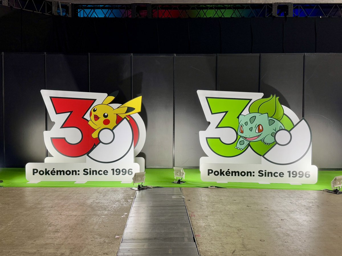 V_Jump's tweet photo. ポケモンジャパンチャンピオンシップス2026 会場の展示物紹介

①入口 
光と音の演出でド派手にお出迎え。

②ポケモン30周年ロゴパネル
ロゴに入って撮影できます。ピカチュウ、フシギダネ、ヒトカゲ、ゼニガメの4つ。

③ポケモンヒストリーピックアップ！
ポケモンやPJCSの歴史をまとめた年表。

④ポケモン30周年ぬいぐるみフォトスポット
ぬいぐるみをセットして撮影。来場予定の方はお気に入りポケモンを連れて行こう！ 明日デデンネ持って行きます。
#PJCS2026