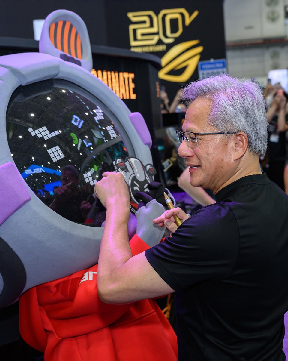 ASUSROGJP's tweet photo. COMPUTEXのROGブースに
NVIDIAのCEO Jensen Huang 氏が来訪！✨

20周年記念モデルの2つに特別なサインが刻まれました。

ROG Crosshair X870E Edition 20
ROG Astral GeForce RTX 5090 Edition 20

もちろん、OMNIもサインをねだるチャンスを逃さなかったようです。🤭💚

#ROGComputex2026 #ROG20thAnniversary