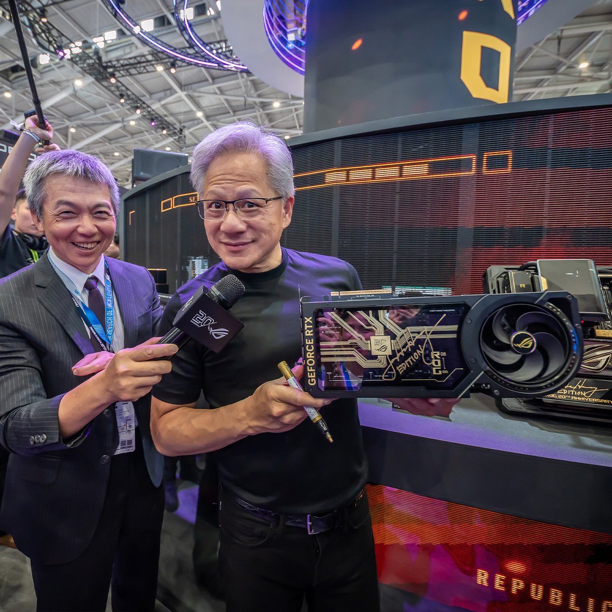 ASUSROGJP's tweet photo. COMPUTEXのROGブースに
NVIDIAのCEO Jensen Huang 氏が来訪！✨

20周年記念モデルの2つに特別なサインが刻まれました。

ROG Crosshair X870E Edition 20
ROG Astral GeForce RTX 5090 Edition 20

もちろん、OMNIもサインをねだるチャンスを逃さなかったようです。🤭💚

#ROGComputex2026 #ROG20thAnniversary