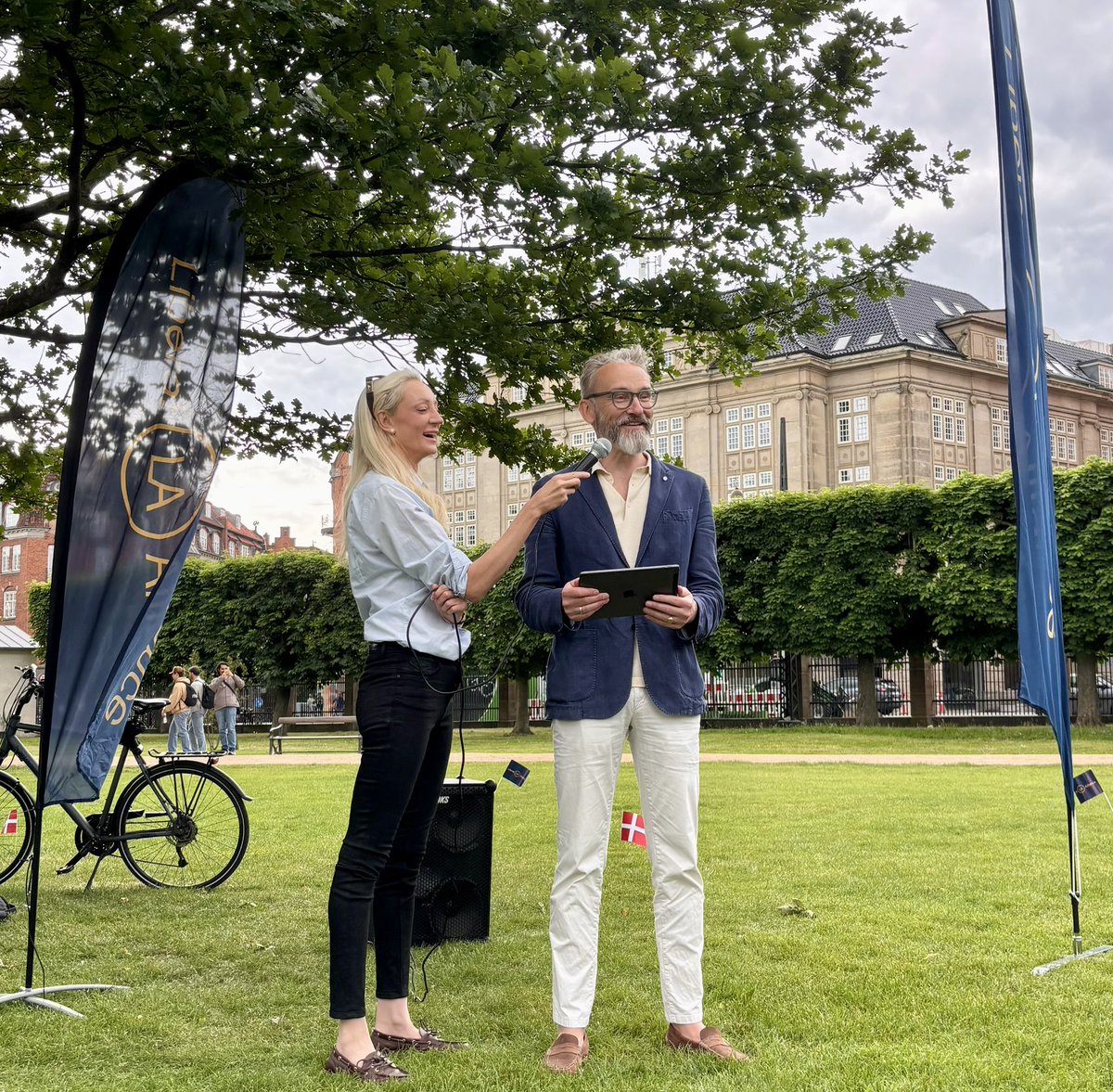 olebirkolesen's tweet photo. Så er grundlovstalen holdt i Kongens Have i København. Tak til Cirkeline Vemmer med logistikken, når der både skal holdes mikrofon og scrolles på iPad!

——————

Grundlovstale 2026
 
Grundlovsdag er det liberale demokratis festdag.

Vi har lige overstået et folketingsvalg, og journalister har for vane at kalde valgdagen for demokratiets festdag.

I denne uge fik Danmark en ny regering, og det fik også en tv-journalist til at kalde dén dag for demokratiets festdag.

Men det er nu grundlovsdag, som er vores liberale demokratis rigtige festdag. For sådan et demokrati, som vi har i Danmark, handler jo ikke kun om repræsentative valg til vores Folketing. Og det handler endnu mindre om indsættelsesdagen for nye ministre fra landets udøvende magt.

Vores demokrati handler om, at vi har en overenskomst med hinanden om betingelserne for, at staten udøver magt over borgerne. Vi synes simpelthen, at den magt er så farlig, at vi har besluttet, at der skal være regler for dens udøvelse, og de regler kalder vi vores ”grundlov”.

Hos os er det ikke engang nok, at et flertal af borgerne vil noget, eller at der er flertal i Folketinget for det. Det skal også være tilladt i henhold til vores grundlovs paragraffer at gøre det, som flertallet gerne vil gøre. Et folketingsflertal kan sådan set beslutte hvad som helst, men hvis det strider mod Grundloven, hvad flertallet har besluttet, så kan vores Højesteret erklære det ulovligt i henhold til Grundloven.

På den måde skal selv det Folketing, som laver lovene, overholde en lov, når Folketinget gør det, og det er godt. Ellers ville det eneste, som begrænsede Folketinget, være Jungleloven, hvor de stærkeste bare kan gøre, hvad de vil med de mindre stærke.

Det er formaliteterne i vores liberale demokrati, som de er givet af Grundloven. De er på plads her i Danmark.

Men vores folkestyre hviler også på en kultur, på sædvane og på normer. Det uformelle.
Danmark er ikke kun et velfungerende demokrati pga. det formelle, men også pga. det uformelle. Den måde vi omgås på i det daglige og også den måde, vi omgås på, når vi diskuterer politik borgere og borgere i mellem og også mellem politikere og borgere.

Her kommer Danmark fra et godt sted. Men er vi også godt på vej? Det kan jeg godt blive i tvivl om efter den valgkamp, vi har været igennem.
Vi plejede at være et land, hvor man kunne stole på hinanden. Endda kunne man også regne med politikere i valgkamp. Sådan cirka.

Det skete i gamle dage, at politikere i valgkamp lovede mere, end de havde tænkt sig at holde, når valget var overstået. Men så faldt der også brænde ned!

I 1998 lovede Poul Nyrup Rasmussen, at han modsat Uffe Ellemann-Jensen ville bevare efterlønnen uændret, og det vandt han valget på. Men straks valget var overstået, lavede han alligevel efterlønnen om.

Kæmpe skandale! Ugevis med forsider om løftebruddet. Meningsmålingerne styrtdykkede for Socialdemokratiet, og partiet mistede regeringsmagten tre år senere til Anders Fogh Rasmussen, som gik til valg på, at ham kunne man – modsat Nyrup – stole på. Fogh ville aldrig love noget i valgkampen, og så gøre det modsatte efter valget, sagde han.

------------

(1/3)