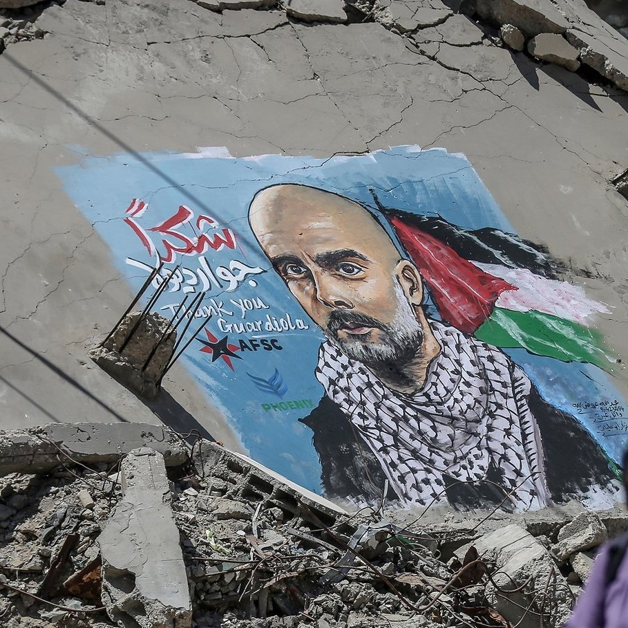 OunkaOnX's tweet photo. Artists in Gaza City have painted a mural of former Manchester City manager Pep Guardiola on a damaged, debris-covered wall, expressing gratitude for his public support of Palestinians https://t.co/57Hffw673u