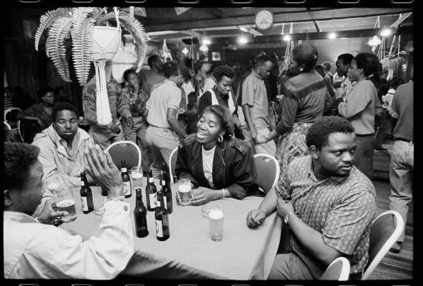 HistorySAZAR's tweet photo. People enjoying themselves in a South African 'shebeen', circa 1990. Credit: Jurgen Schadeberg https://t.co/zQLyWIc8wA