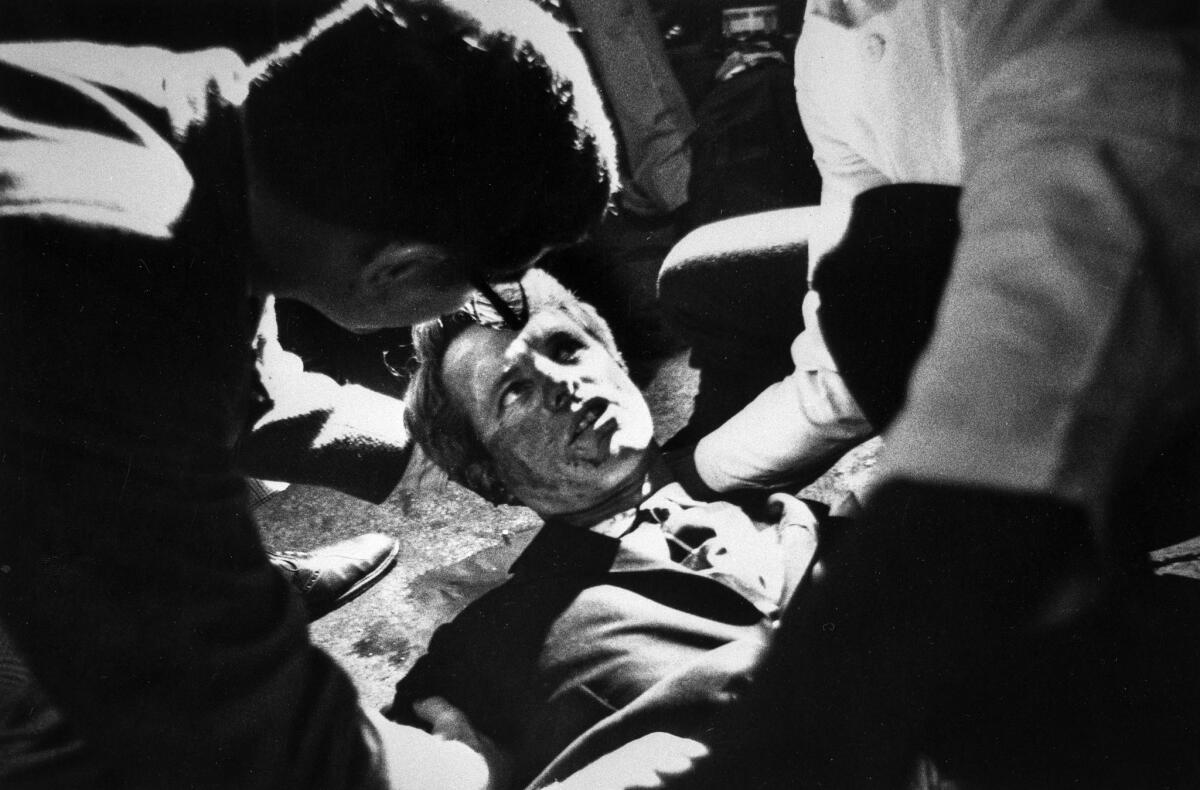 EchoesofWarYT's tweet photo. Just after midnight on June 5, 1968, Robert F. Kennedy finished his victory speech in the Ambassador Hotel ballroom with the words "and now it's on to Chicago, and let's win there."

He had four minutes left as a conscious man, and the way those minutes unfolded still haunts American history.

To save time, his bodyguard led him through the hotel kitchen. RFK did what he always did: he stopped to shake hands with the workers. He was reaching for the hand of Juan Romero, a 17-year-old busboy, when Sirhan Sirhan stepped forward and fired.

The photo everyone knows is Romero kneeling on the concrete floor, cradling the senator's head. The boy pressed a rosary into his hand. Witnesses heard Kennedy ask, "Is everybody OK?" Romero told him yes. Kennedy answered, "Everything's going to be OK."

He died the next day. He was 42.

Consider what that one moment took. Two months earlier, on the night Martin Luther King was murdered, it was Kennedy who stood on a flatbed truck in Indianapolis and broke the news to a Black crowd, speaking off the cuff about his own brother's killing for the first time in public, quoting Aeschylus from memory. Indianapolis stayed calm that night while a hundred cities burned.

Now, in the space of nine weeks, the country lost them both.

His funeral train ran from New York to Washington, and something happened that nobody planned: more than a million Americans appeared along the tracks. Factory workers holding hard hats over hearts. Little League teams at attention. People standing in rivers to see it pass. The train ran hours late because the crowds never stopped.

Juan Romero carried that night for the rest of his life. For decades he believed that if Kennedy hadn't stopped to shake his hand, he might have lived. He finally visited the grave in 2010 and said he felt the senator would have told him to be proud, not sorry.

Whatever 1968 was supposed to become ended on that kitchen floor, 58 years ago today.