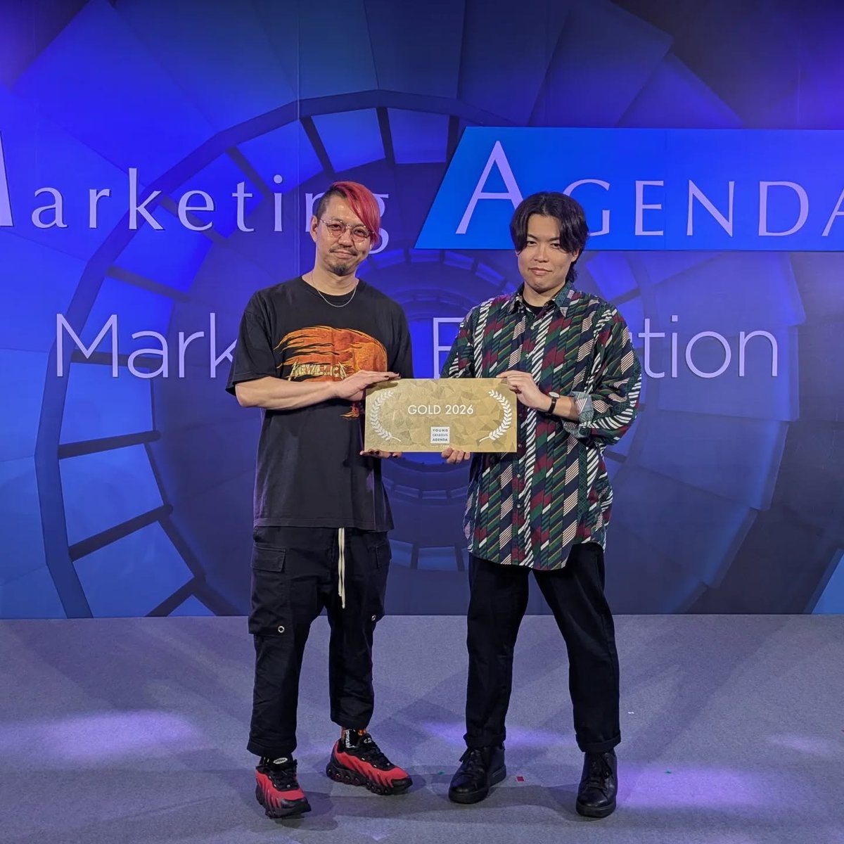 marupoke15's tweet photo. U35の広告クリエイティブコンペティション「ヤング・クリエイティブ・アジェンダ2026」の決勝戦に出場し、ゴールドを受賞しました！🏆

100名以上の若手クリエイターが参加した大会で、予選で勝ち残った10組が沖縄に遠征。

オランダのビール「ハイネケン」の広告企画を考える課題で、40時間で企画書を作りプレゼンテーション…というプログラムでした🍺

400名以上のマーケターの方の前でフリップ芸を披露。ウケてくれてホッとしました…！
