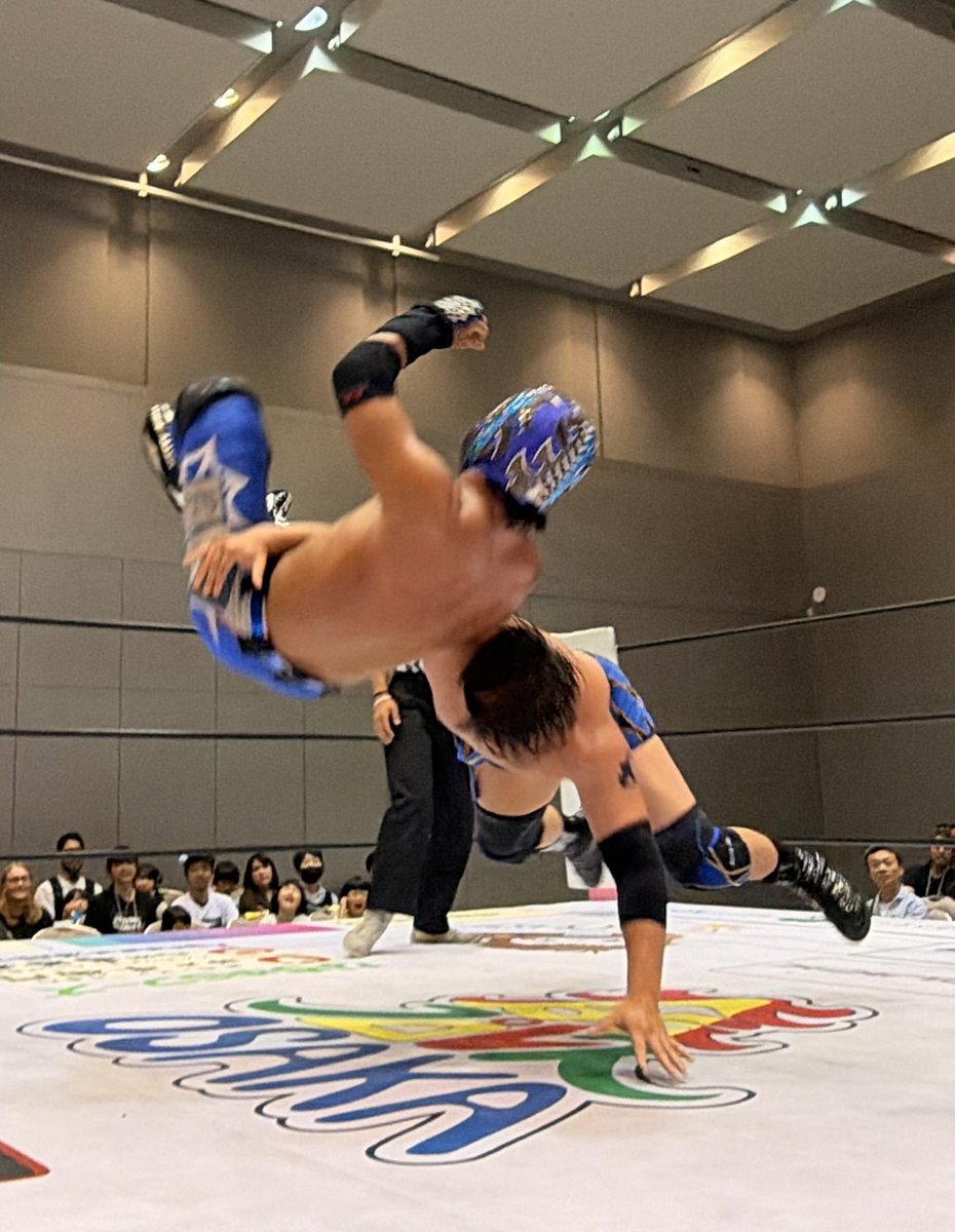 osakapro's tweet photo. 株式会社NAGATUKASA Presents 大阪プロレスけいはんなプラザ大会

第1試合
松房龍哉＆●アルティメット・スパイダーJr vs SUZAKU＆○佐野蒼嵐
（16:32 無双）

タッグ選手権を翌日に控えた佐野蒼嵐とアルティメット・スパイダーJrの前哨戦。序盤は蒼嵐のタックルに対し、スパイダーがコルバタで応戦し互角の展開となる。

松房とSUZAKUがリングインすると、SUZAKUが持ち前のスピードで主導権を握り、松房やスパイダーを翻弄。蒼嵐との連携でスパイダーを捕らえ、逆エビ固めで追い込んでいく。
スパイダーはドロップキックで脱出し松房にタッチ。松房は素早い動きで蒼嵐をかく乱し、SUZAKUにも膝蹴りやクロスボディを浴びせる。
対するSUZAKUもレッグラリアットからムーンサルトプレスを決め、見応え十分の攻防を繰り広げた。

終盤、スパイダーはファルコンアローやトラースキックで猛反撃。SUZAKUのノータッチ・トペコンヒーロも飛び出し会場を沸かせる。

しかし最後は蒼嵐がスピアー、デスバレーボムと畳み掛け、必殺の無双を炸裂。激戦を制した蒼嵐が勝利を飾った。

#大阪プロレス
