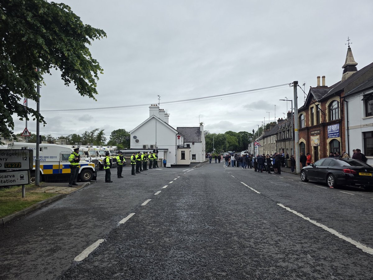 krizab's tweet photo. Tension, heavy police presence, helicopters, British and Israeli flags in the small unionist village of Scarva, Northern Ireland, as protestors wait for a pro-Palestinian ‘March for Gaza’ to pass by https://t.co/HyDLP8IGBK