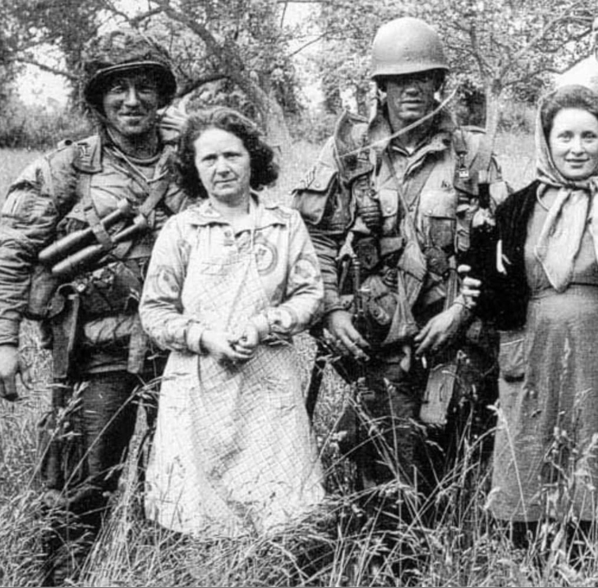 Jason_R_Burt's tweet photo. After making their first combat jump 82 years ago today, paratroopers Forrest Guth and Floyd Talbert of Easy Company pose for a photo with some locals in Normandy, France. https://t.co/wsIHM3nQXb
