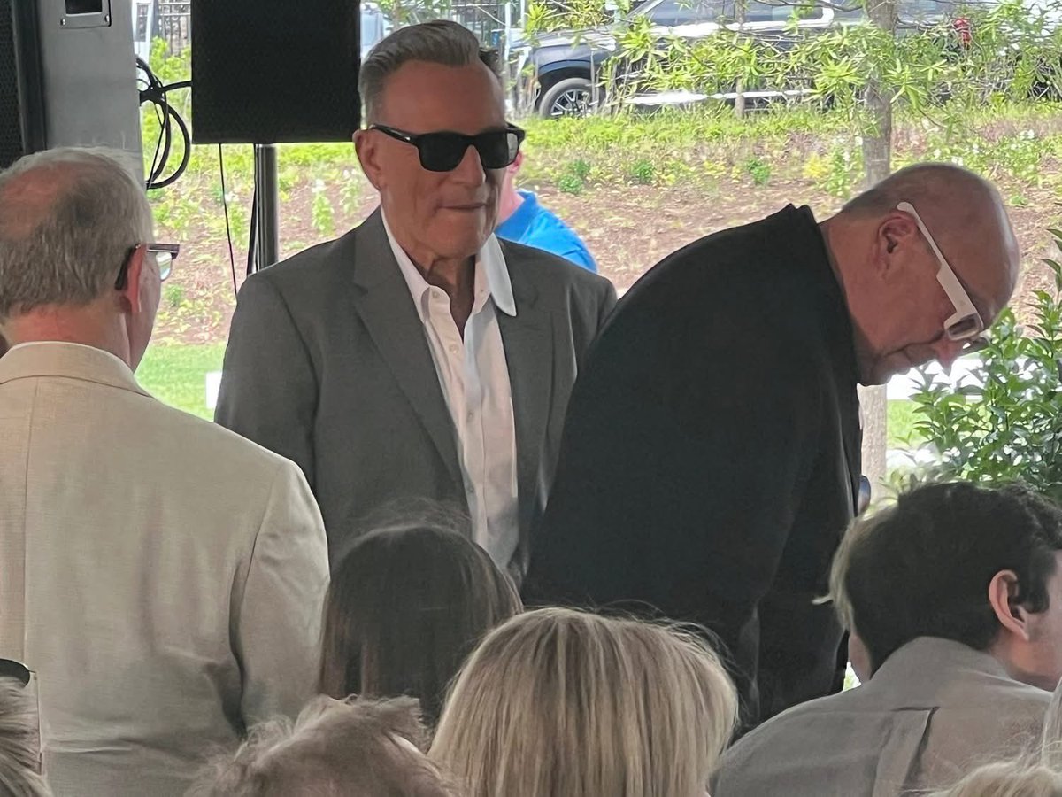 SpringNuts_'s tweet photo. Saturday morning was the dedication and ribbon cutting for the official opening of the Bruce Springsteen Center for American Music in technically Long Branch on the campus of Monmouth University.  

 Bruce Springsteen and his wife Patti Scialfa were at the ceremony along with their son Sam and his wife, Bruce's sisters Ginny and Pam, New Jersey Governor Mikie Sherrill and many other musicians and dignitaries.

 The ceremony took place under a tent in the parking lot of the Center. 
 Bruce spoke last and was very visibly moved. He started his speech saying "Excuse the sunglasses for it's getting a little misty here."
 He said, "I'm also glad and relieved that fans will have another place to go instead of my house."

 He thanked his parents, thanked many at Monmouth University who made this center possible including Eileen Chapman and was emotional as he said, "I got to thank my beautiful wife of 35 years. It's our anniversary (June 9). Without her, so much of this simply would not exist. Her love, her talent, her patience, her support are essential to everything I do and I have done. She is my heart, my soul, she has struggled,  and she is my hero and my favorite E Street Band member." 

He continued, "The mighty E Street Band, who without them, I wouldn't be here. The impact they give me on a nightly basis -- the power, the heart, the soul and complete dedication. ... They deliver for me night after night after night for the past 50 years. Thank you fellas. .... Well this is the wonderful beginning of something that I hope will bring life, hope, creativity education, dreams and inspiration to this campus, our community and our country. I'm deeply honored to be a part of it. Thanks."  

The ceremony in front of about 300 people began at 11 a.m. and was over at 12:30 p.m.
 
Melissa Kozlowski, the Center's director of curatorial affairs, was the emcee. Speakers included Monmouth University President Patrick Leahy; Joy Hargo, the U.S. poet laureate (2019–22); Governor Sherrill, Bob Santelli, the executive director of the Center, and Jon Landau who introduced Bruce.

A formal ribbon cutting then took place to open the Center. 

Among the audience: Jon Bon Jovi, Jackson Browne, Max Weinberg, Garry Tallent, David Sancious, Vini Lopez, Charlie Giordano, George Travis, Ron Aniello, Thom Zimny, Kevin Buell, Lisa Lowell, Rich Russo, Jake Thistle, Erik Flannigan, Jimmie Vaughan, Sonny Kenn, Marc Ribler, Woody Guthrie's daughter Nora, Brian Williams, and photographers Rob DeMartin, Danny Clinch, Eric Meola and Frank Stefanko.   

There was pre-ceremony music by the New Breed Brass Band from New Orleans and during the ceremony, David Sancious played a beautiful version of "New York City Serenade."