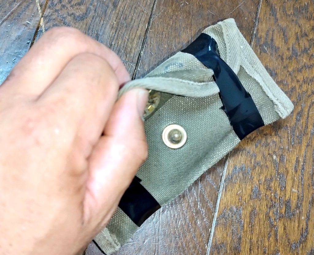 karasigotyo's tweet photo. Hound様に私からコメントした「救急品袋」の脱落防止について説明いたします。よく写真の様に二箇所をブラックテープで巻きますが、これはちょっとした事では開かないかつ、必要時には蓋部を持ち上げる事でテープが延びて包帯を取り出せるためです。あまりグルグル巻きや中心寄りに巻いてはいけません https://t.co/GyxoB4QhL3