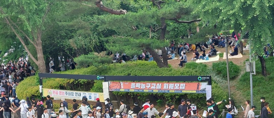 DrTaraO's tweet photo. 2026-6-7. Olympic Park, Seoul. A strange group was controlling the entry to the rally area. They forced people to form a line and go around to enter the area. Why? Who are they? They said they're "spontaneous volunteers," yet they acted like a well-organized group. Someone told them to direct the people to go in the rally area 1 by 1, standing in a line. They claimed its for safety, but I don't see why going into a large open area requires a line. They were forceful about it. One older man (see photo) pushed me to go in a line going in a different direction. I've never seen this. People should be free to come and go. This group claims they're not an organization,  but they act very well organized & coordinated.
수상한 자발적이 아닌 조직이 "자발적인 개인"이라며 올림픽공원 을 자유롭게 들어가지 못하고 줄서서 들어가게 통제를 일요일 (6.7) 부터 하고 있어요. 이상하지요?