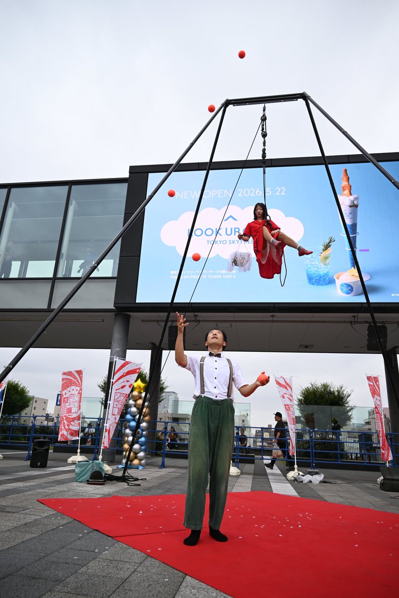 takewacky's tweet photo. ソラマチ大道芸フェスティバル2026、2日目。ソランポ・ソランその3。ちょうど長すみ絵さんがデジタルサイネージの前に吊られるので映像とリアルとの融合みたいなことになるのだが、どんなに気象条件が悪くても、お外のライブが一番楽しい。 https://t.co/W9CZZ7uvcQ