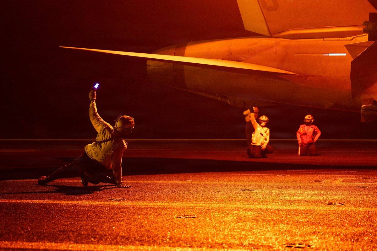 CENTCOM's tweet photo. Sailors aboard USS George H.W. Bush (CVN 77) conduct night flight operations while transiting the Arabian Sea. George H.W. Bush is one of two aircraft carriers currently operating in the Middle East. https://t.co/YBk8INc3Kg
