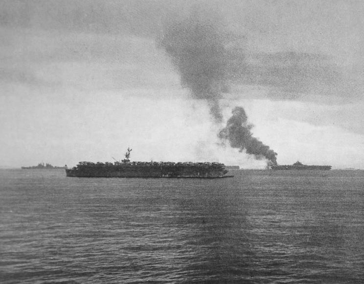 HiddenHistoryYT's tweet photo. Smoke rising from the forward flight deck of the USS Randolph, San Pedro Bay, Leyte Gulf, Philippines, 7 Jun 1945, after a USAAF P-38 Lightning accidentally crashed into a group of parked airplanes; photograph taken from aboard USS Texas https://t.co/ftg1IeD4DQ