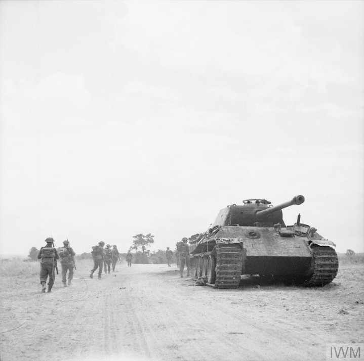 WW2Facts's tweet photo. British troops walking past a knocked out German Panther Ausf. A in Normandy, France, in June, 1944.

#History #WWII https://t.co/TlD6b1Zh50