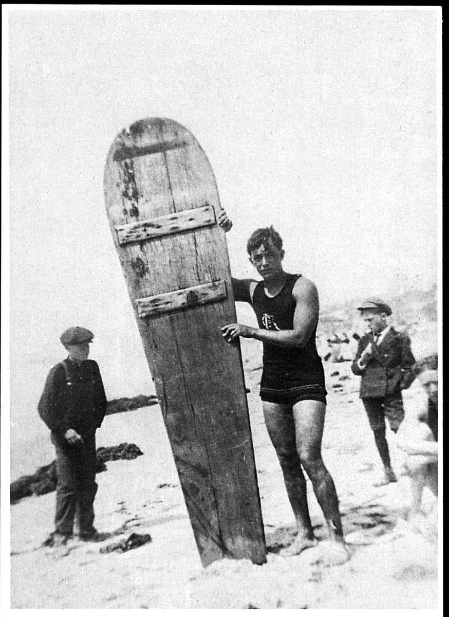 pastarchive's tweet photo. George Freeth with an early wooden surfboard, c. 1914. Born in Waikiki, Freeth helped bring Hawaiian surf riding to Southern California, giving public demonstrations that introduced many mainland spectators to the sport long before lightweight modern boards existed. https://t.co/ef9zyR8uCM