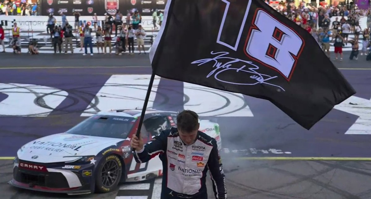STaranto92's tweet photo. One of Denny Hamlin's crewmembers ran out an 18 flag - a combination of Kyle Busch's number at Joe Gibbs Racing and the 8 he ran in recent years - to Hamlin after the checkered flag. 

Hamlin took the flag, turned backwards down the frontstretch, and then did his burnout before holding the flag aloft after he climbed out of his car in honor of his longtime teammate, who he now ties for ninth on NASCAR's all-time Cup wins list with 63.

Hamlin also made mention of Ned Jarrett, the original star driver of the No. 11, who passed away Thursday at the age of 93.