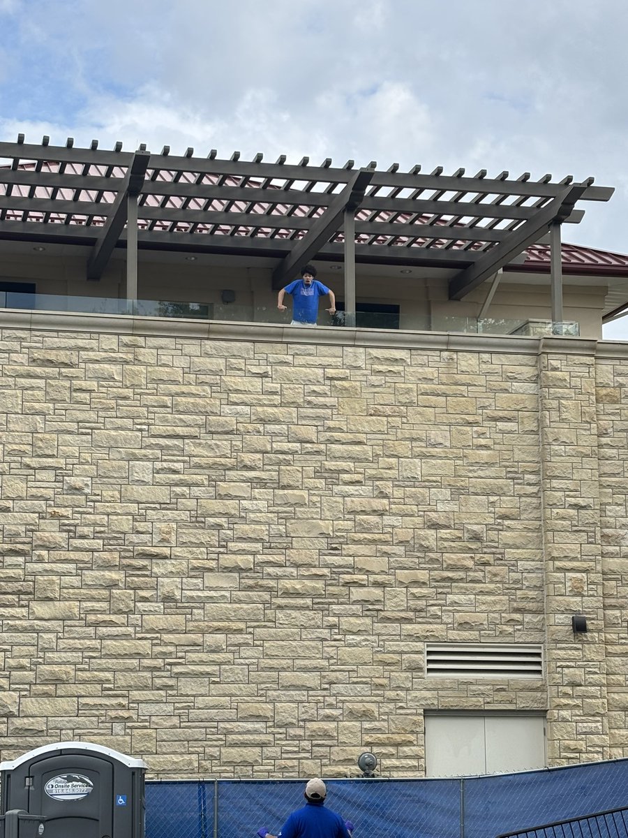 gabeswartz_'s tweet photo. Tyran Stokes just emerged onto the balcony of McCarthy Hall to ask KU fans in “The Backyard” if anyone knows when first pitch is. 

We remain in a rain delay with no first pitch time scheduled. @KCTV5 https://t.co/CIdhxkZSrV