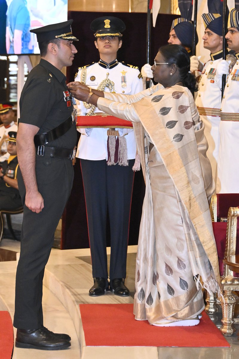 rashtrapatibhvn's tweet photo. राष्ट्रपति द्रौपदी मुर्मु ने मेजर अर्शदीप सिंह, दि कवचित कोर, 1 असम राइफल्स, को अद्वितीय वीरता और असाधारण नेतृत्व के लिए कीर्ति चक्र प्रदान किया। एक विशेष गश्ती दल का नेतृत्व करते हुए वे ऊँचाई से की गई गोलीबारी की चपेट में आ गए। रॉकेट प्रोपेल्ड ग्रेनेड लांचर के साथ आसन्न खतरे को पहचानते हुए, उन्होंने झाड़ियों के बीच से रेंगकर सटीक गोलीबारी से कई सशस्त्र कैडरों को मार गिराया।