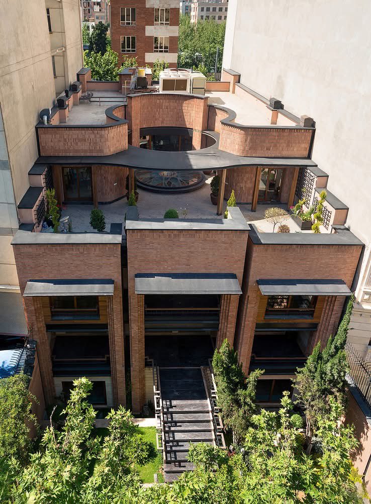 shavnyuyngah's tweet photo. Iran has been under Western sanctions for over 40 years. And somehow they are producing some of the most sophisticated brick architecture on the planet.

Kaveh House, Tehran. A decaying three storey residence in a dense neighbourhood. Pargar Architecture did not demolish it. They cut a skylight through its core, wrapped it in handlaid curved brick towers referencing Persian masonry traditions going back centuries, added a roof garden, layered balconies and brought daylight into the basement through a deliberate facade setback.

The curved brick towers are not only decorative. They are load bearing forms shaped by the same logic Iranian builders have refined for generations.

A country whose economy is being squeezed from the outside is producing some of the most intelligent urban architecture being built anywhere right now.

Pargar Architecture and Design Studio | Tehran 🇮🇷 | 1,400 m² | 2013
📸 Hossein Farahani, Mehrdad Emrani