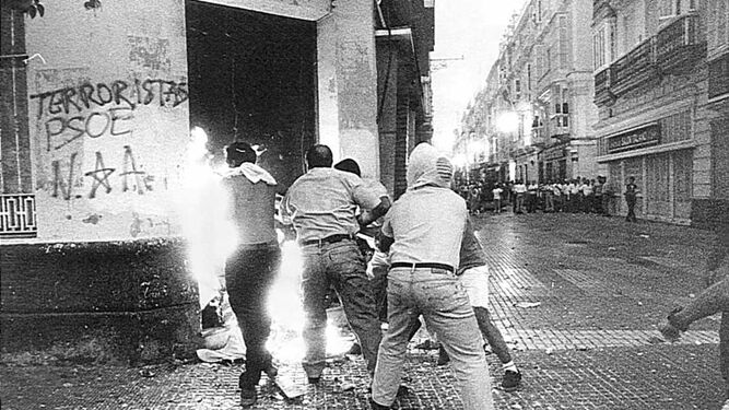 outsidersesp's tweet photo. "Puerto Real, una localidad situada en la bahía de Cádiz y cuya economía giraba en torno a un enorme astillero, supo a finales de 1986 que el gobierno planeaba cerrarlo. Pero, a diferencia del resto de localidades, en Puerto Real la CNT tiene fuerza suficiente como para oponer resistencia a los planes del Estado.

Mientras los sindicatos «representativos» insisten en criticar la política del gobierno, la CNT explica a la gente que la crisis es un problema del capitalismo y que son sus ejecutivos los que tienen que buscar las soluciones que para eso cobran: la obligación del pueblo es defender sus puestos de trabajo y luchar por una sociedad justa, sin caer en trampas de hacer planes alternativos. La CNT dinamiza las asambleas, las radicaliza para que se exprese claramente cuál es su sentir, habla con la gente...

El 8 de enero de 1987 se celebra una asamblea en el astillero, y a propuesta de CNT se corta la carretera de acceso a Cádiz; en esta jornada se enfrentan a la policía: se forman barricadas, la policía carga y se producen algunos heridos. Será el primero de una serie de días en los que el pueblo de Puerto Real luchará contra las fuerzas de represión, los medios de comunicación, las manipulaciones políticas de partidos y sindicatos... barricadas cada martes, cortes de tráfico, manifestaciones, concentraciones, asambleas, protestas estudiantiles...

El 10 de febrero arde una arqueta de telefónica dejando 14.000 teléfonos fuera de servicio. El gobernador civil, Mariano Baquedo, afirma que «los disturbios son ocasionados por una minoría de trabajadores. Todos los demás no comparten los métodos violentos empleados por esta minoría» y amenaza con ocupar los astilleros (lo que se intentará días después).
La CNT le responde que «los cortes de tráfico se decidían por mayoría en las asambleas, por lo que no es cierto que esas manifestaciones sean protagonizadas por una minoría de violentos. No somos violentos. Violentos son ellos que nos roban la dignidad quitándonos el trabajo. Estamos hartos de mil y una promesas incumplidas y no nos dejan otro camino que luchar permanentemente por nuestros puestos de trabajo. Que contraten barcos, verán cómo no estaremos en la carretera ni en la calle, sino trabajando».

Las fuerzas policiales intentan asaltar la factoría a comienzos de marzo, acorralando a los trabajadores que se refugian en un barco en construcción, quedando sitiados hasta que la llegada masiva de personas a la factoría (unos 3000) desborda totalmente a la policía que inicia su repliegue seguida de gritos de ¡A la calle! Y ¡Fuera de mi casa!

Las mujeres se autoorganizarán como asamblea mientras que los sindicatos «representativos», incapaces de contener a la gente, son agredidos.
El gobernador civil en un ataque de nervios declara a la prensa que «son una banda de terroristas. A veces estoy deseando el estado de excepción... en cualquier caso yo sólo soy gobernador civil y mi misión no es contratar barcos».

La CNT le responde: «Se está llevando a los trabajadores a un clima de desesperación... pero claro, esto al señor gobernador debe importarle bien poco. No es de su competencia. Demasiado ocupado anda el hombre apareciendo en inauguraciones, entregas de placas y otras fiestas a las que es tan aficionado». Al día siguiente será cesado en su cargo por su evidente incompetencia, pero la policía continuará su política de acciones de terror organizado, a las que se une la empresa declarando ilegalmente el cierre patronal. El 9 de abril, son ya 8.000 personas las que cortan la carretera, y hasta los niños juegan a policías y manifestantes.

El 27 de mayo 27.000 personas se manifiestan por las calles, y el Estado y Comité de Empresa inician negociaciones para parar las protestas. El protagonismo pasa entonces a las mujeres, que continúan con su política de enfrentamientos y cortes de carretera, siendo apaleadas, atacadas con gases, pelotas de goma, chorros de agua a presión, porras..., repitiendo a pesar de ello sus acciones sin echarse atrás, mostrando bastante más coherencia que los hombres; el 7 de julio un niño de 12 años es herido y apaleado cuando defendía a su madre. El 9 de junio, la CNT reinicia las protestas en solitario, y el gobierno finalmente se rinde: «milagrosamente» el astillero tendrá trabajo, gracias a contratos con Francia para la construcción de barcos. La fuerza de las asambleas populares, el rechazo al politiqueo y el «problema de orden público» fueron la base de la victoria: sin ello, el astillero de Puerto Real habría sido desaparecido víctima de la reconversión."

(Publicación original de Colectivo Editorial Amor y Rabia)