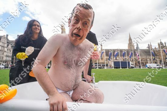 stretchwomble's tweet photo. Nigel Farage impersonator gets a scrub down in a bathtub in Parliament Square as part of anti corruption campaign to clean up Westminster  #reformUK #nigelfarage more pics on https://t.co/V3nKUpou4f https://t.co/S8IbV0pS7U