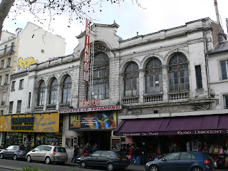 merlinpapin3's tweet photo. Aujourd’hui, dans le cadre de mes #CinémasdeQuartierdemaVie qui ont façonné ma cinéphilie, je vais vous parler d’un lieu mythique de Paris, classé à l’inventaire des monuments historiques : #LeTrianon, situé boulevard Rochechouart, à proximité du métro Anvers (enjtre Pigalle et Barbès)
Ce lieu a marqué une période de ma vie, lorsque j’y allais encore lorsqu’il était en format “salle de cinéma”.
Amusante proximité avec l’Élysée Montmartre, haut lieu du catch en France dans les années 60 et 70, devenu aujourd’hui un espace fréquenté par la jeunesse branchée de Paris et de province, qui vient s’y divertir lors de concerts (Indochine, BB Brunes, Stromae), mais aussi pour des pièces ou des spectacles contemporains.
Mais autrefois, tout était différent.
Le Trianon a été créé en 1894, en tant que théâtre à l’italienne, avec ses deux balcons, son plafond haut et vaste, et ses piliers courant tout le long de la salle. Il pouvait accueillir jusqu’à 1 000 personnes dans une salle à la fois longue et large, très éloignée des “cages à lapins” que proposent certains circuits aujourd’hui.
À ses débuts, il s’appelait Trianon Concert et a changé plusieurs fois de nom avant de devenir simplement Le Trianon. Mais cette première vie fut interrompue : un incendie important détruisit la salle ainsi qu’une partie de son voisinage. Il fut reconstruit et rouvrit en 1902.
Avant la guerre, il se spécialisa dans le music-hall, accueillant des artistes comme Fréhel, Guibert ou Pierre Dac.
Puis, après la guerre et pendant près de quarante ans, la salle devint un cinéma, l’un des plus côtés de Paris. Sa situation, proche de Pigalle et au pied de Montmartre, attirait un large public qui appréciait la grandeur de la salle et son immense écran. On retrouvait une configuration comparable à celle du Grand Rex, avec ses deux balcons (bien que la décoration fût différente), ses coursives et ses escaliers impressionnants pour un cinéma.
Je l’ai connu dans les années 70, lors de mon arrivée avec ma mère et mon frère dans ce quartier où elle avait emménagé. C’était alors une profusion de cinémas à proximité immédiate de la maison, une faune colorée et bon enfant, une autre époque.
Entre Place Clichy et Barbès, on trouvait une dizaine de salles, presque toutes du même côté de la rue, très fréquentées par des jeunes comme moi. Au Trianon, on pouvait voir surtout des films d’aventure, pas en avant-première, mais cela importait peu.
Puis le cinéma s’est spécialisé dans les films de kung-fu, que nous découvrions avec enthousiasme, tout comme les westerns spaghetti. On y découvrait Bruce Lee, Franco Nero, Terence Hill ou Bud Spencer : un vrai cinéma de quartier, où l’on n’avait pas besoin de réfléchir.
Ce n’étaient pas forcément des chefs-d’œuvre, certes, mais combien d’acteurs devenus célèbres par la suite avons-nous découverts ici ? Eastwood, Bronson ou Van Cleef en faisaient partie.
Une petite part de ma vie de passionné de cinéma s’est construite dans ce type de lieux.
Vers le milieu des années 80, le cinéma ferma comme tous les autres du quartier. Mais lui ne devint jamais un multiplexe et conserva ses ors pour ceux qui le rachetèrent, en en faisant un des hauts lieux de la culture branchée parisienne, au même titre que l’Élysée Montmartre (où a lieu la Soirée des Révalations des César depuis quelques années) La Cigale ou Le Divan du Monde.
Mais ça c'était avant
@FredOL69007
❤️si vous aimez